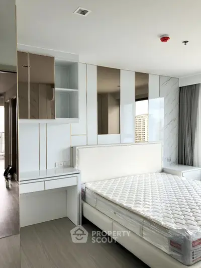 Modern bedroom with sleek design and city view, featuring a stylish bed and built-in storage.