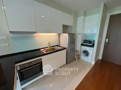 Modern kitchen with sleek appliances and stylish cabinetry in a contemporary apartment.