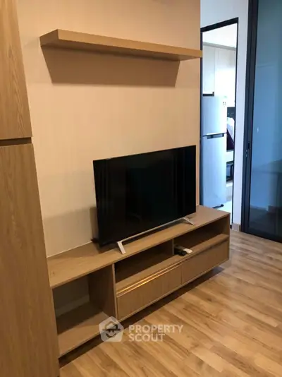 Modern living room with sleek TV stand and wooden flooring in stylish apartment.