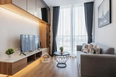 Modern living room with large window, stylish decor, and cozy seating area.