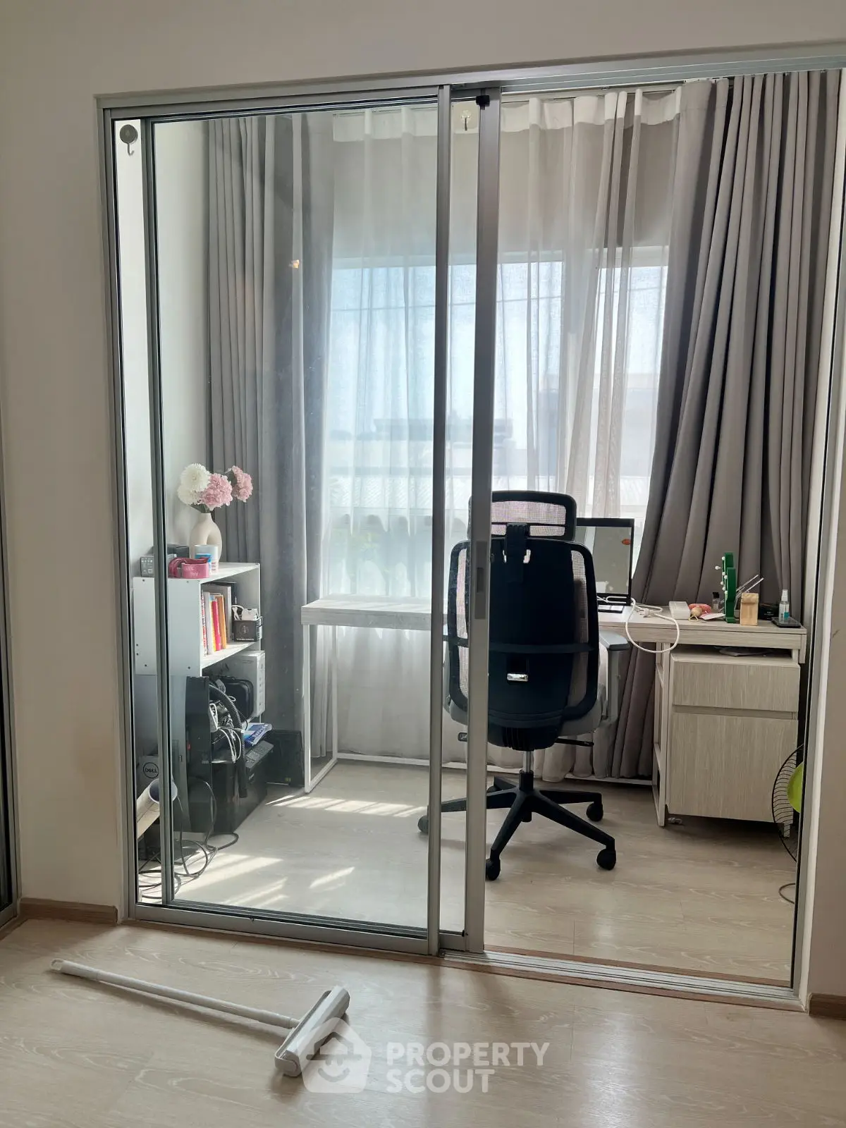 Modern home office with glass sliding doors and natural light