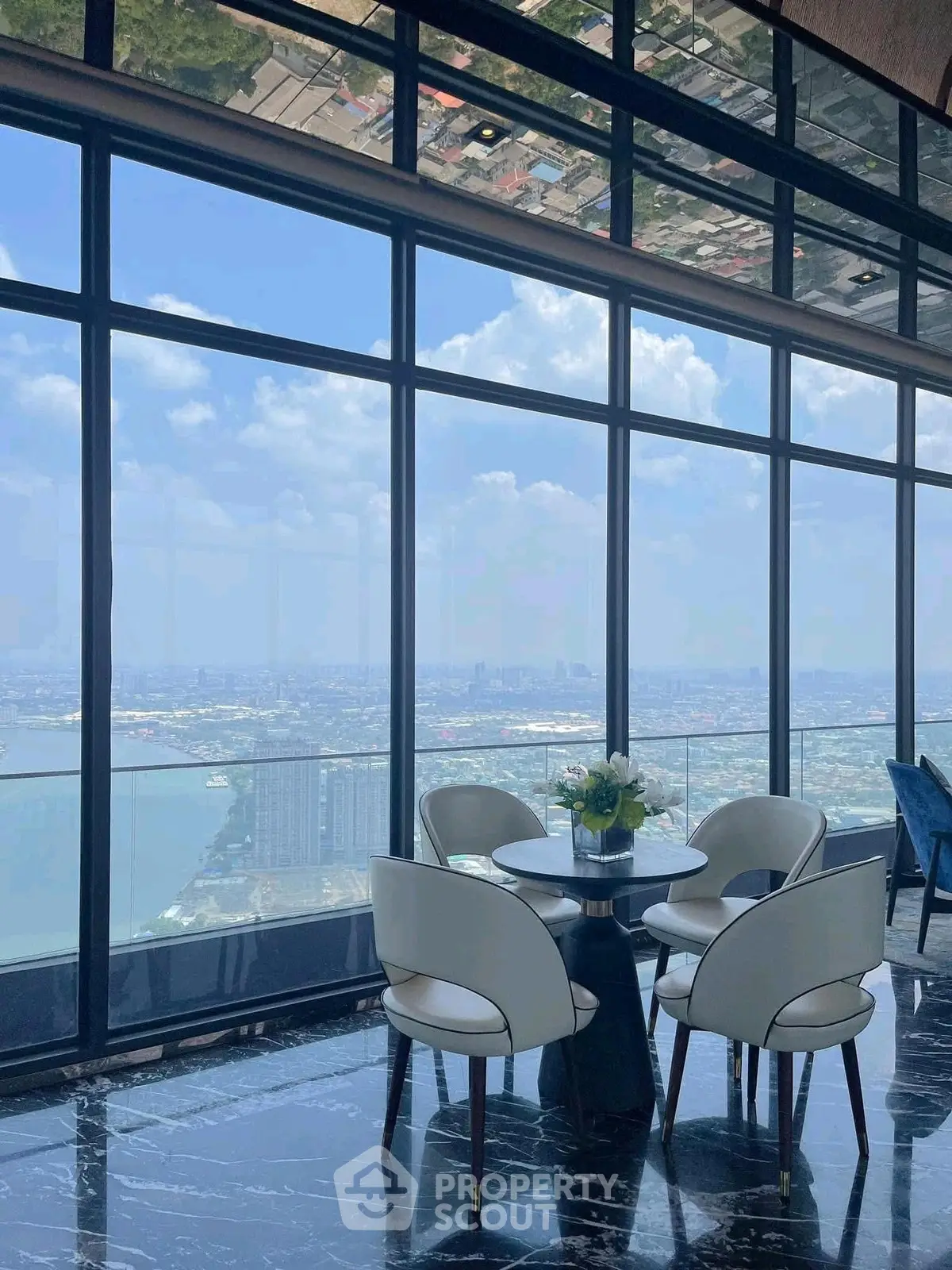Luxurious high-rise apartment with stunning panoramic city and river views, featuring elegant dining area and floor-to-ceiling windows.