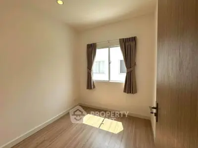 Bright empty room with wooden floor and window, ideal for bedroom or study setup.