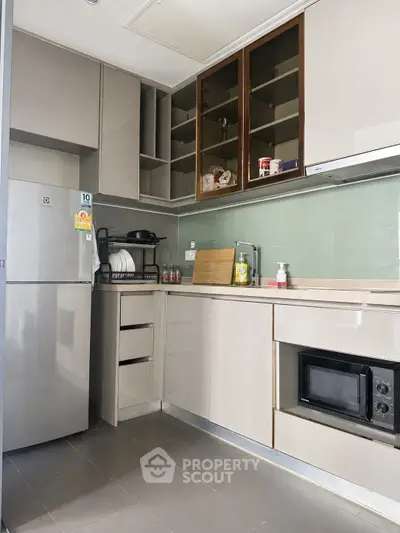 Modern kitchen with sleek cabinetry and built-in appliances, featuring a microwave and ample storage space.