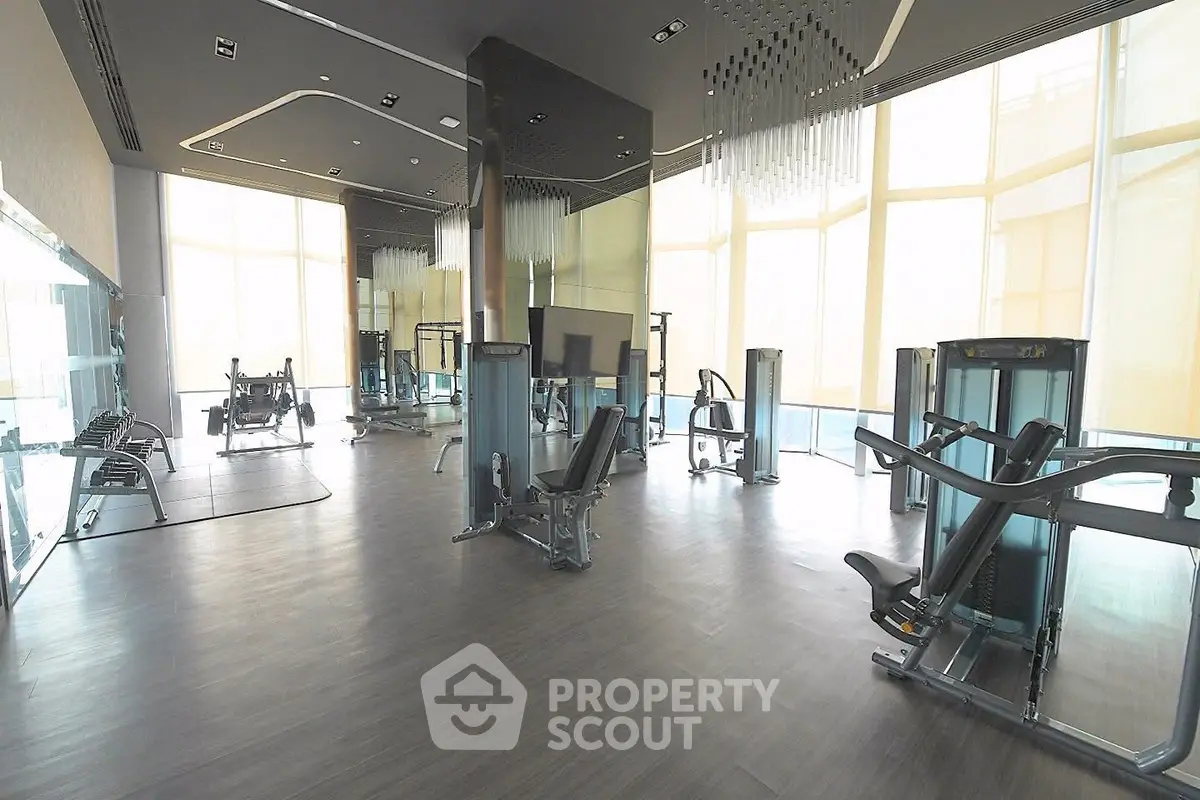 Spacious modern gym with state-of-the-art equipment and floor-to-ceiling windows.