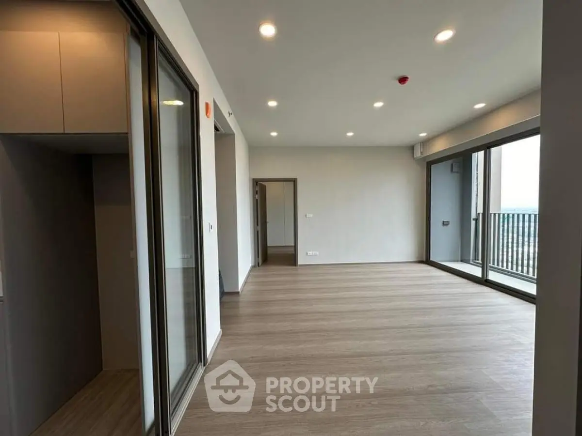 Spacious modern living room with large windows and balcony access