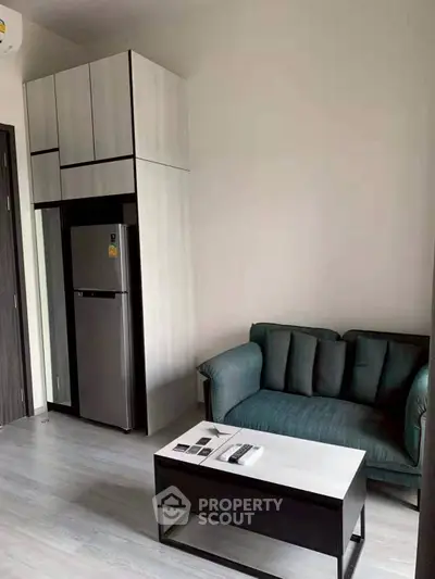 Modern living room with compact kitchen and stylish furniture in a cozy apartment.