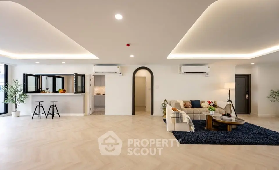 Spacious modern living room with elegant decor and open kitchen layout, perfect for entertaining.