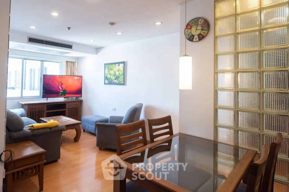 Spacious living room with modern furniture and large TV, perfect for relaxation.