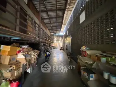 Spacious industrial storage area with high ceilings and ample shelving space.