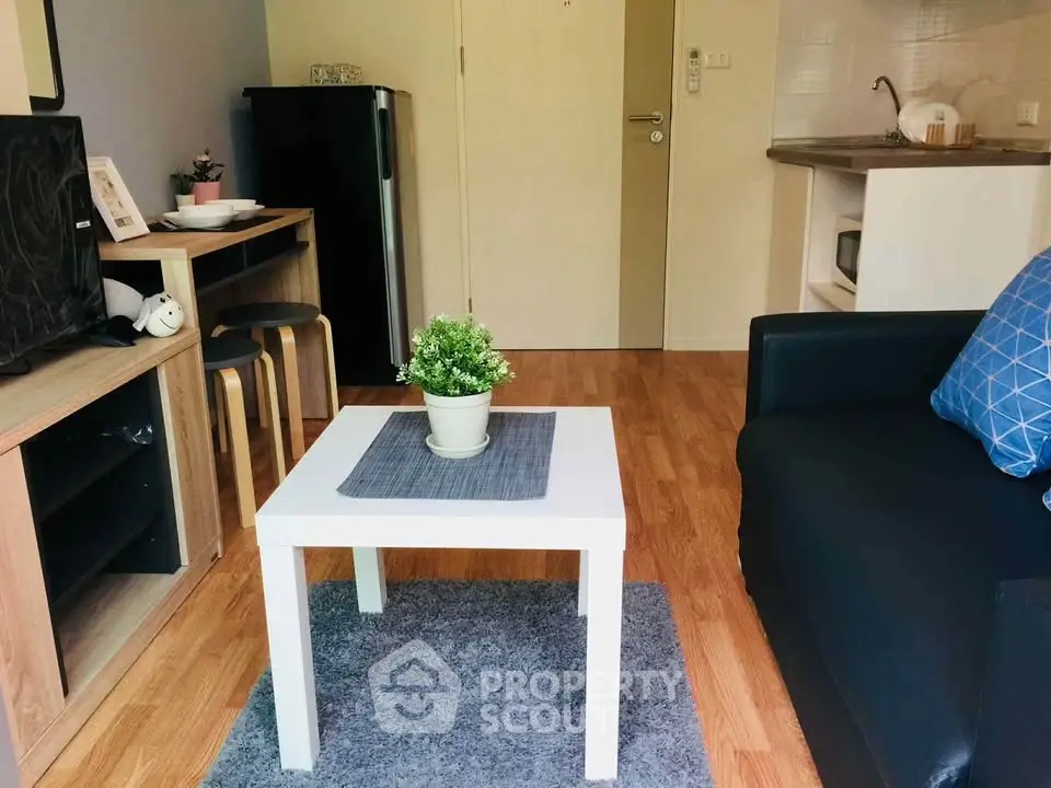 Cozy living room with modern decor and compact kitchen area, perfect for urban living.