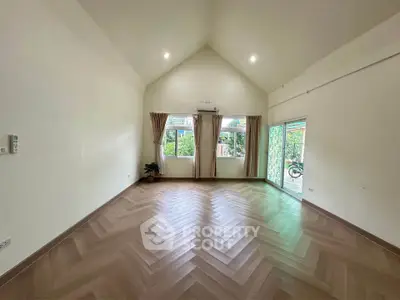 Spacious empty living room with high ceiling and large windows