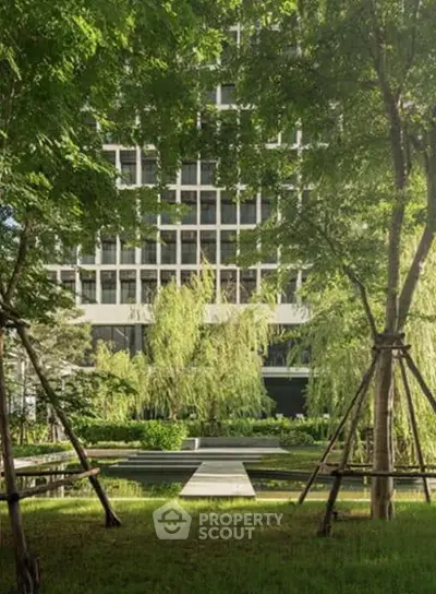 Luxurious building exterior with lush garden and modern architecture.