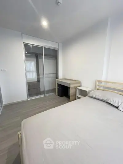 Modern minimalist bedroom with sleek sliding wardrobe and cozy bed setup.
