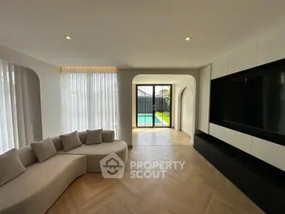 Elegant living room with modern design and pool view, featuring stylish furniture and natural light.