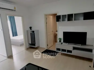 Modern living room with sleek furniture and open doorway to bedroom