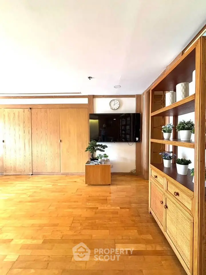 Spacious living room with wooden floors and built-in shelving