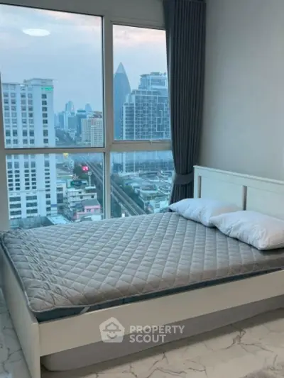 Modern bedroom with city view and large window, featuring a cozy bed and elegant decor.