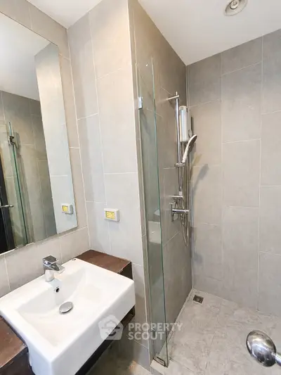 Modern bathroom with sleek fixtures and glass shower enclosure in a contemporary home.