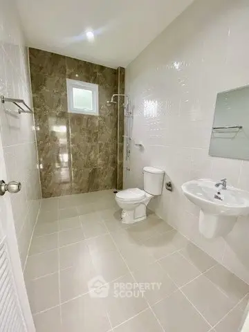 Spacious modern bathroom with elegant tile design and natural light.