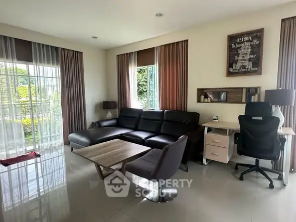 Modern living room with sleek furniture and large windows offering garden views.