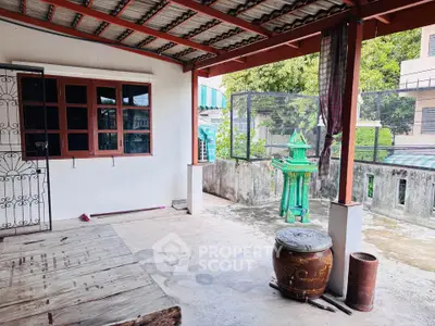 Charming outdoor terrace with traditional decor and garden view, perfect for relaxation and gatherings.
