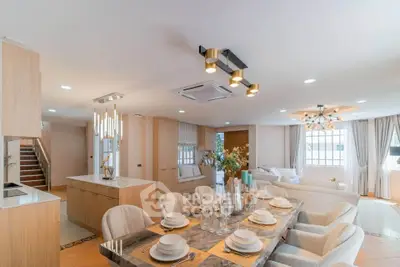 Luxurious open-plan living and dining area with elegant decor and modern lighting.