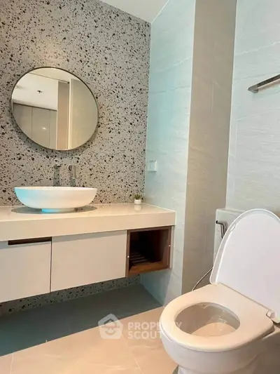 Modern bathroom with stylish round mirror and sleek fixtures