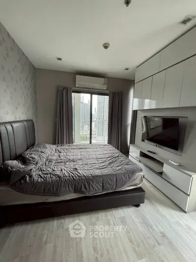 Modern bedroom with city view, featuring sleek built-in storage and stylish decor.