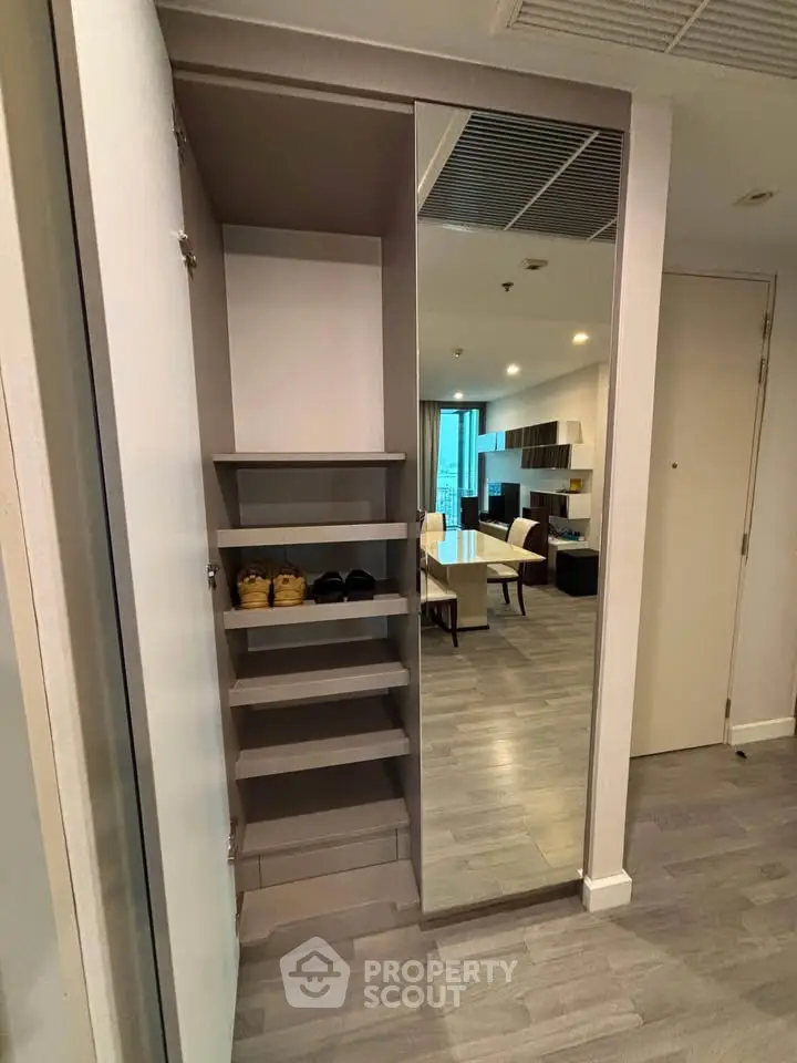 Modern apartment interior with sleek shoe storage and open living area, perfect for urban living.