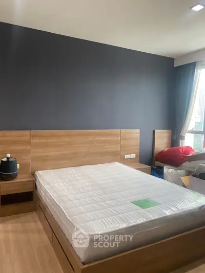 Modern bedroom with wooden furniture and large window, perfect for natural light lovers.