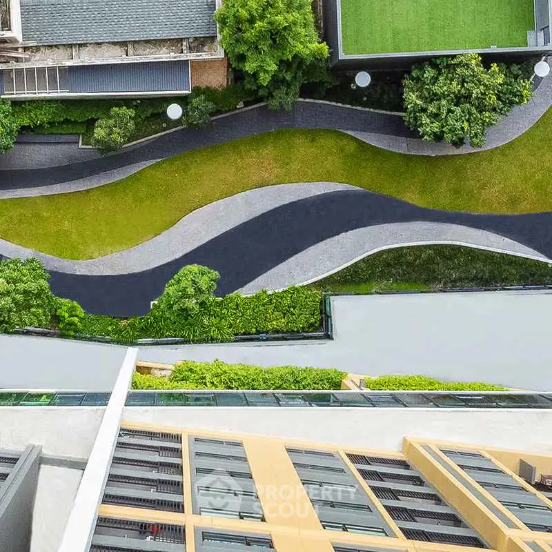 Stunning aerial view of modern building with lush green landscaping and unique architectural design.