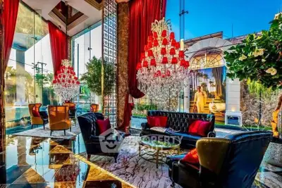 Luxurious living room with high ceilings, chandeliers, and elegant decor.