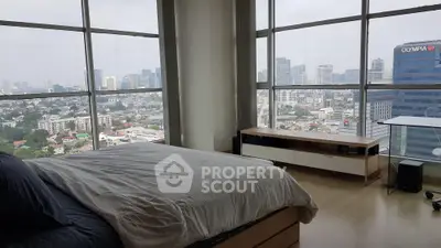 Luxurious bedroom with panoramic city view and modern furnishings in high-rise apartment.