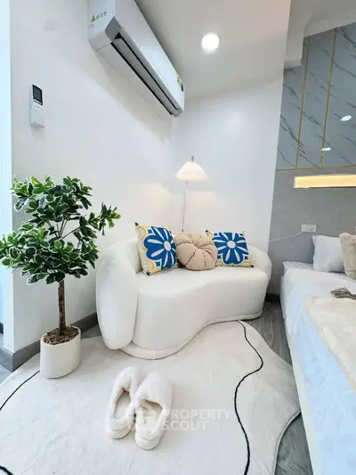 Stylish modern bedroom with cozy seating and elegant decor