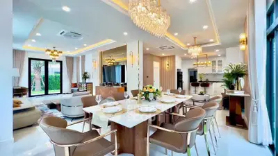 Luxurious open-plan living and dining area with elegant chandeliers and modern decor.