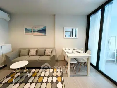 Modern living room with stylish decor and dining area in a bright apartment.