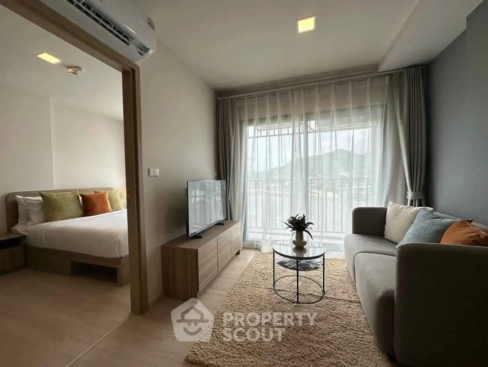 Modern living room with cozy sofa and mountain view, adjacent to stylish bedroom.