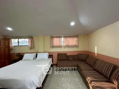 Cozy bedroom with double bed and striped sofa, perfect for relaxation.