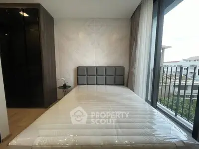 Modern bedroom with large window and balcony view in a stylish apartment