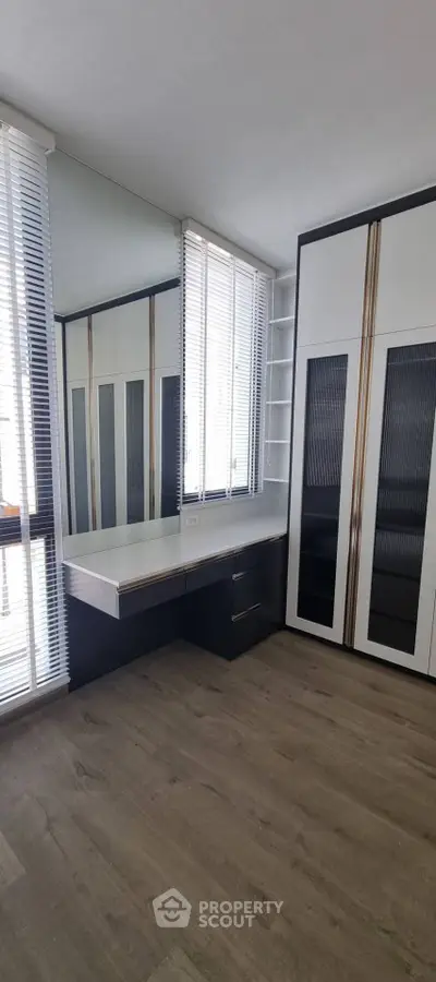 Spacious modern bedroom with built-in wardrobe and large windows