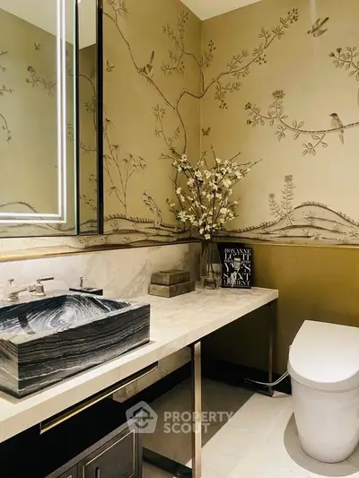 Luxurious bathroom with elegant marble sink and artistic wallpaper design.