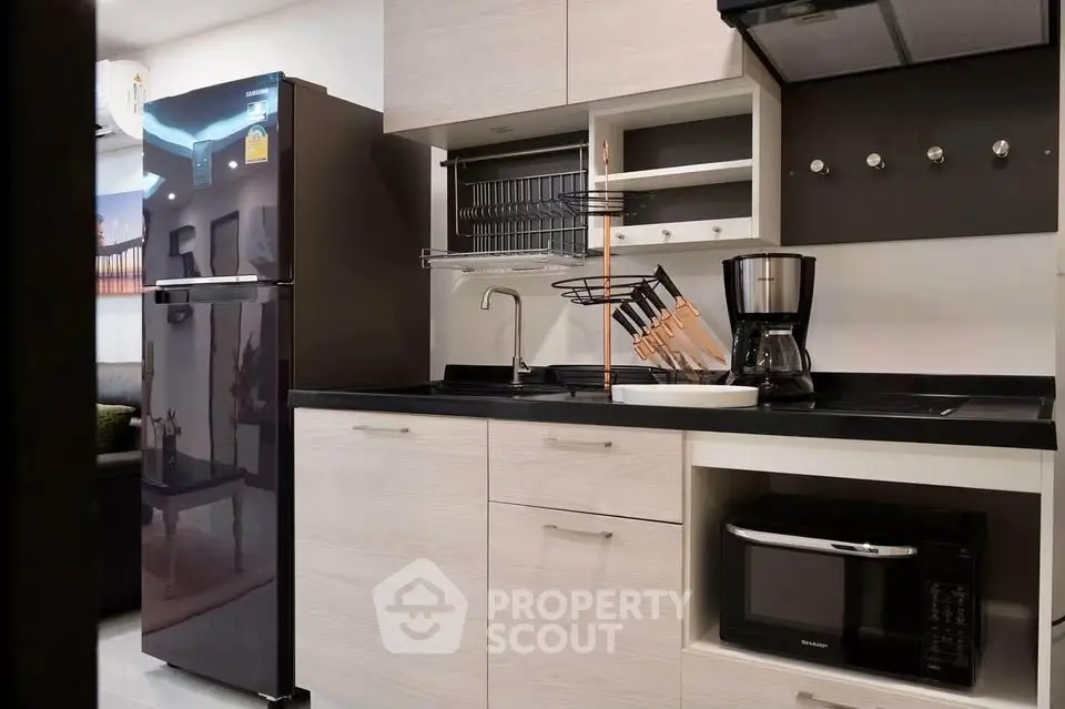 Modern kitchen with sleek appliances and stylish cabinetry in a contemporary apartment.