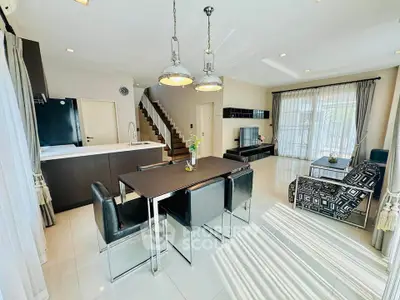 Spacious modern living room with open kitchen and stylish dining area, featuring elegant decor and natural light.