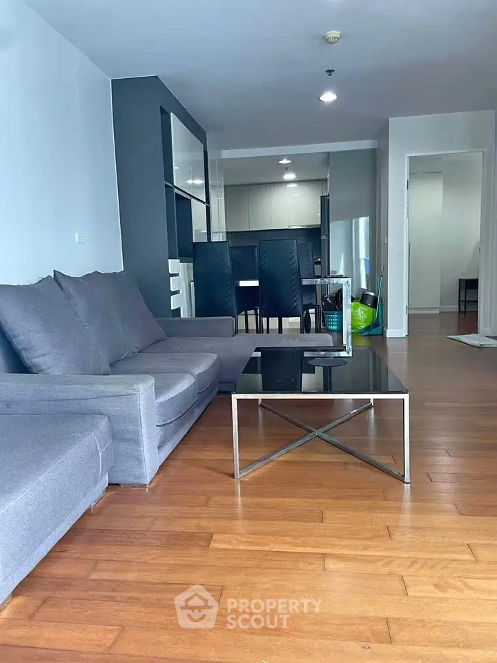 Spacious modern living room with sleek furniture and open kitchen layout, perfect for contemporary living.