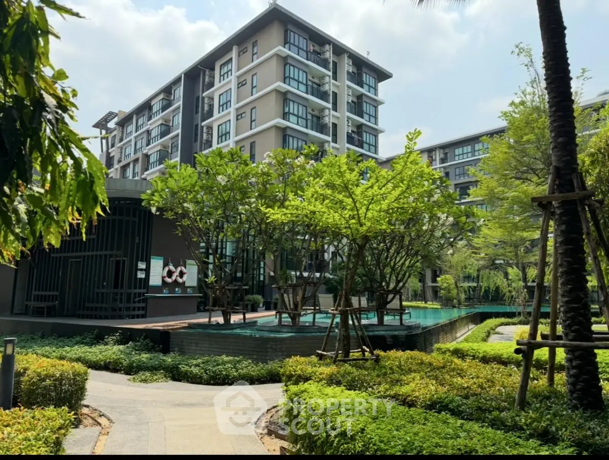 Modern apartment building with lush garden and pool view, perfect for urban living.