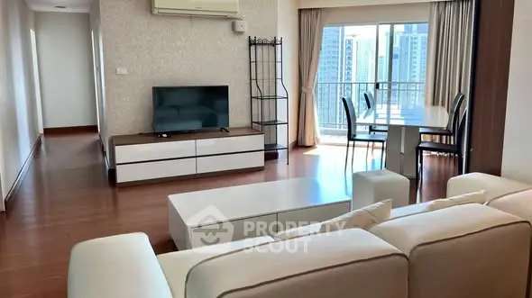 Spacious living room with modern furniture and city view balcony.