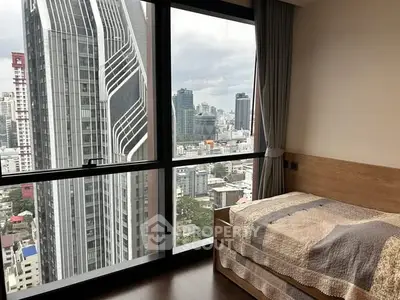 Modern bedroom with stunning city view from high-rise building window.