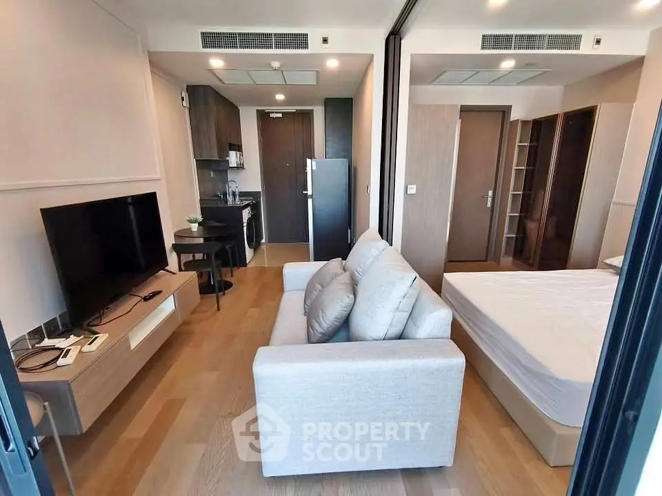 Modern studio apartment with open layout, featuring a cozy living area and compact kitchen.