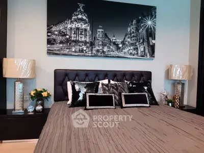 Luxurious bedroom with elegant decor and stylish artwork, featuring plush bedding and modern lighting.
